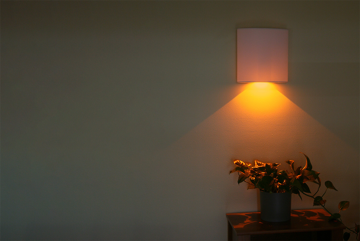 Healthcare patient room at night with amber night wall sconce. 