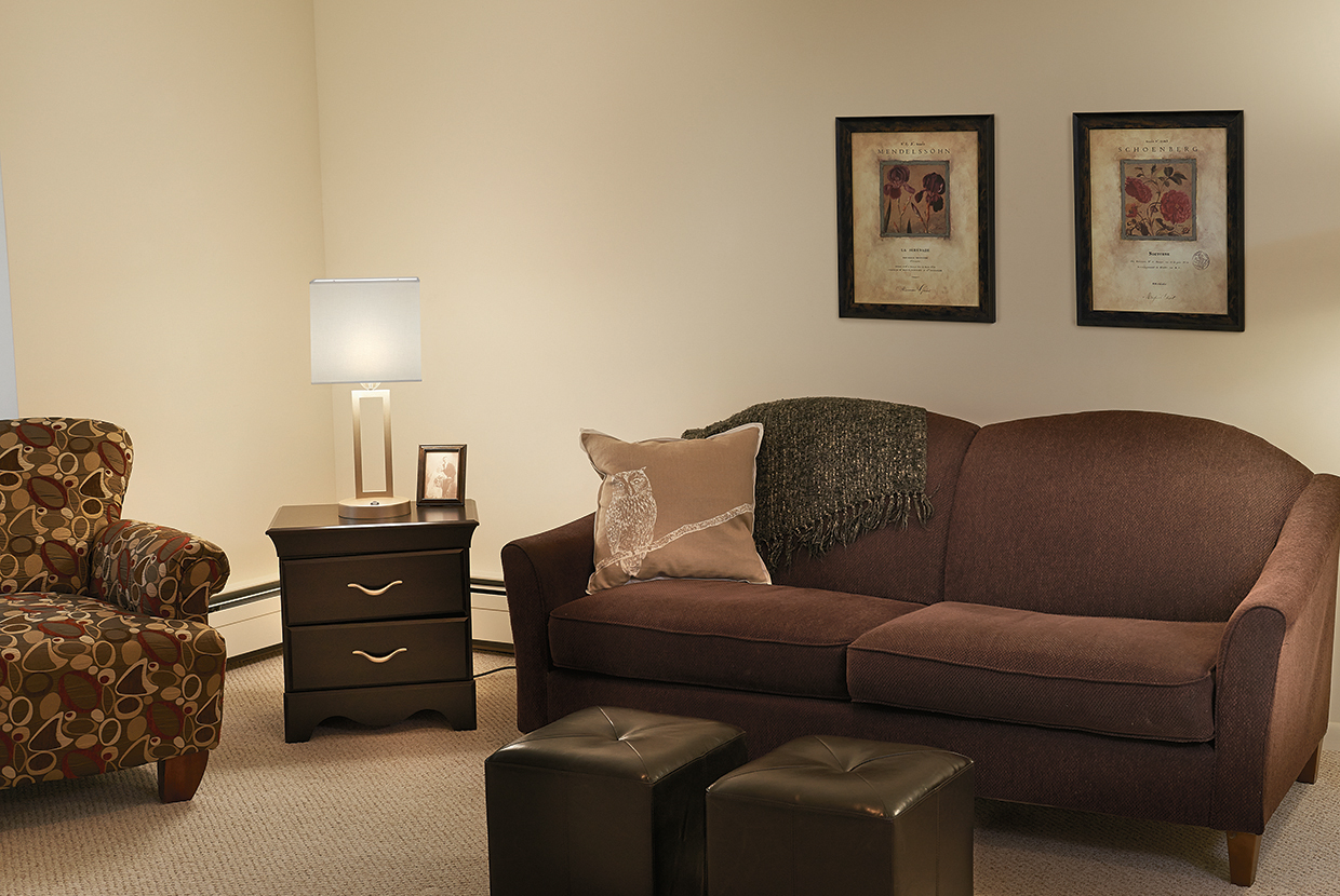Allegro portable luminaire for senior living and multifamily design provide a soft, glowing light over a living room.