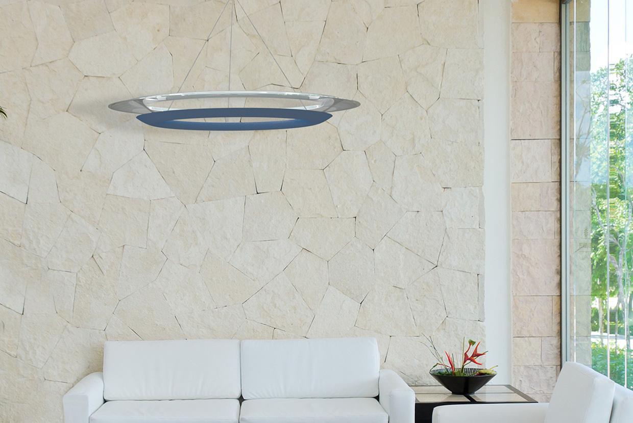 Blue and white ring pendant light hanging in waiting room with white couch and stone wall