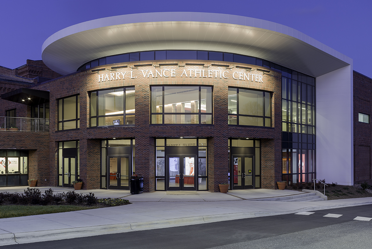 Advantus exterior lighting fixtures illuminate a sign on an athletic center at night. 