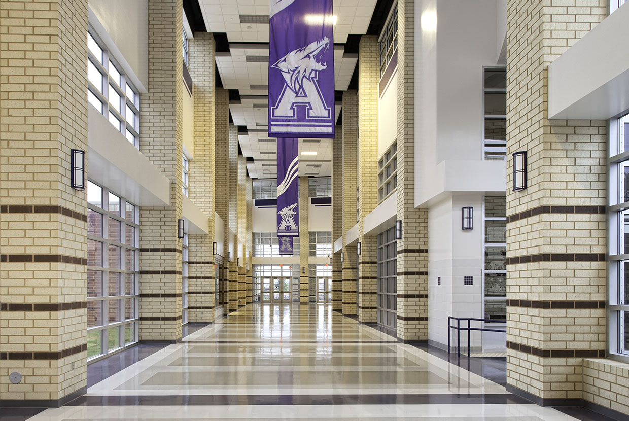 Midland Arts timeless wall sconces in an education lighting application along a campus sports facility corridor. 