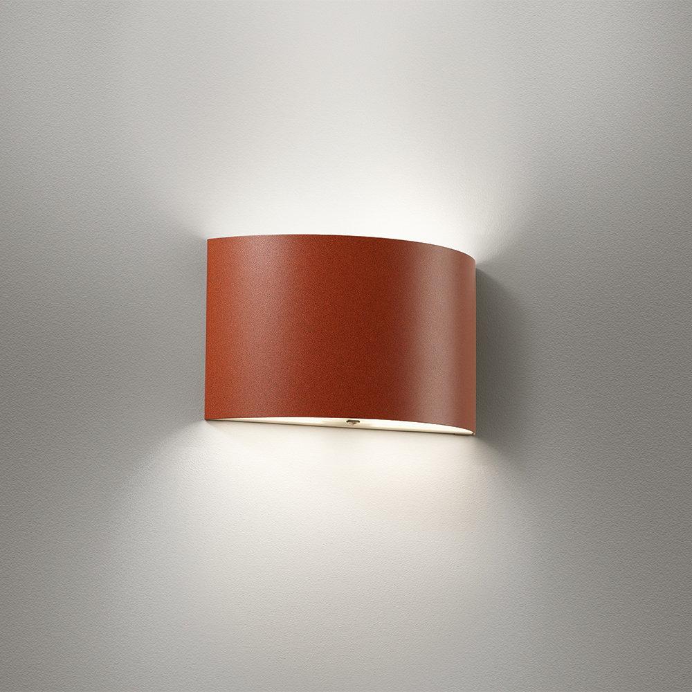 Curved wall sconce with a solid body and up and downlighting