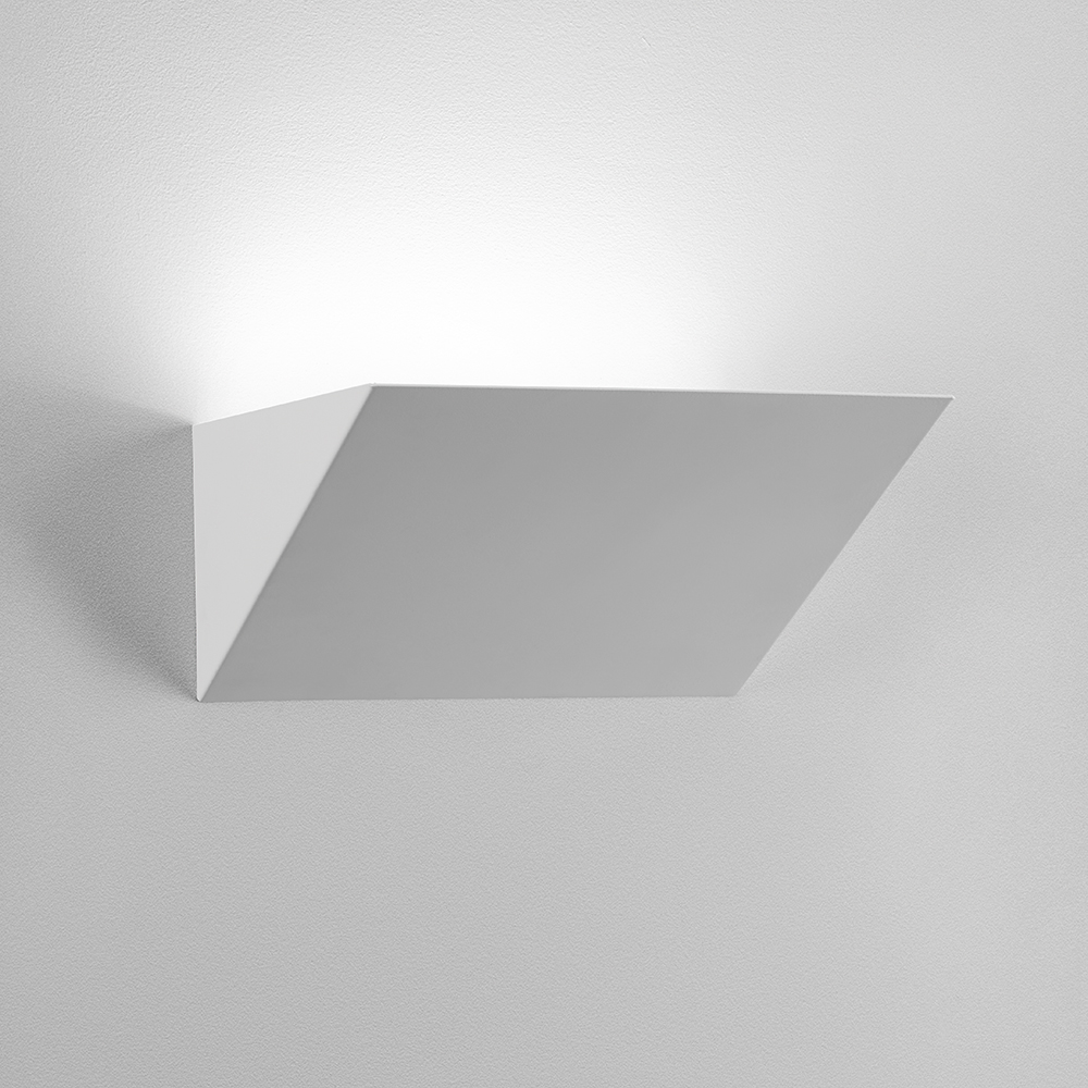 A sharp, angled indirect wall sconce with a solid body