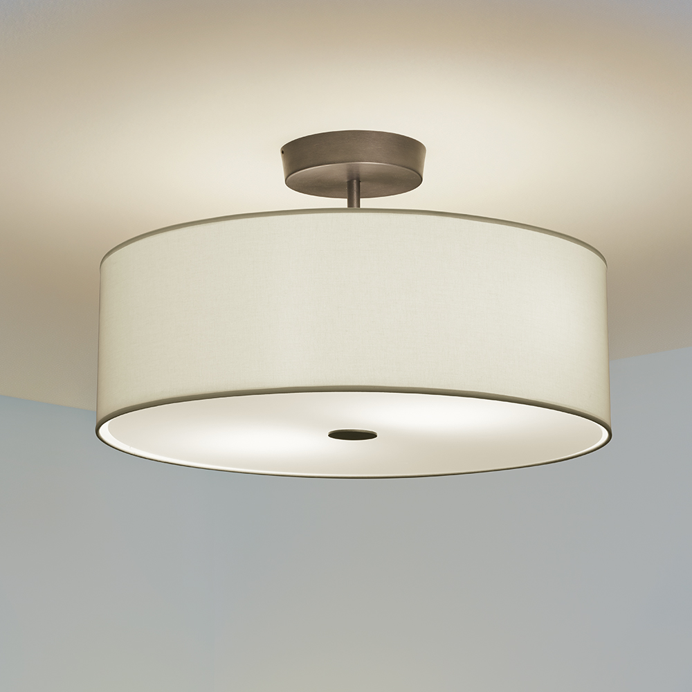 A ceiling mounted drum fixture with a fabric-looking shade