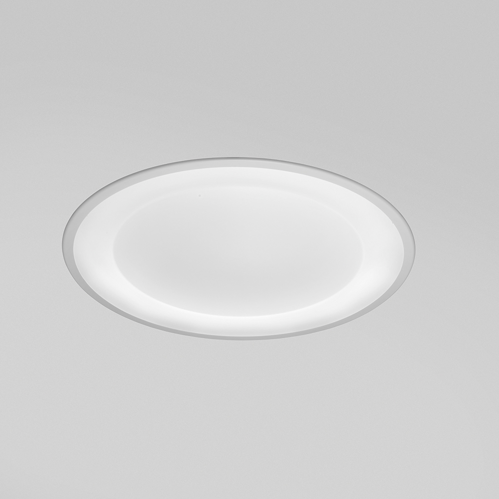 A round, recessed ceiling luminaire with a concave dome lens 