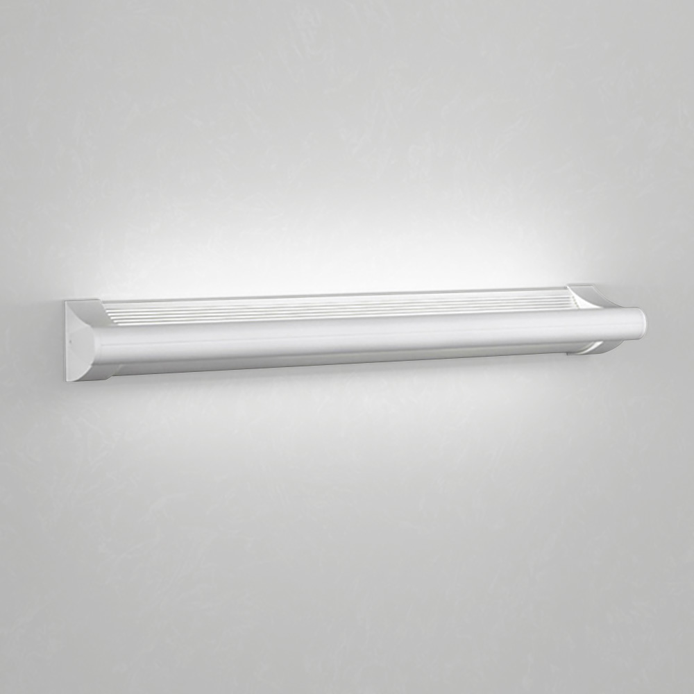 A surface mounted linear luminaire with a body that curves into the base with hidden indirect lighting