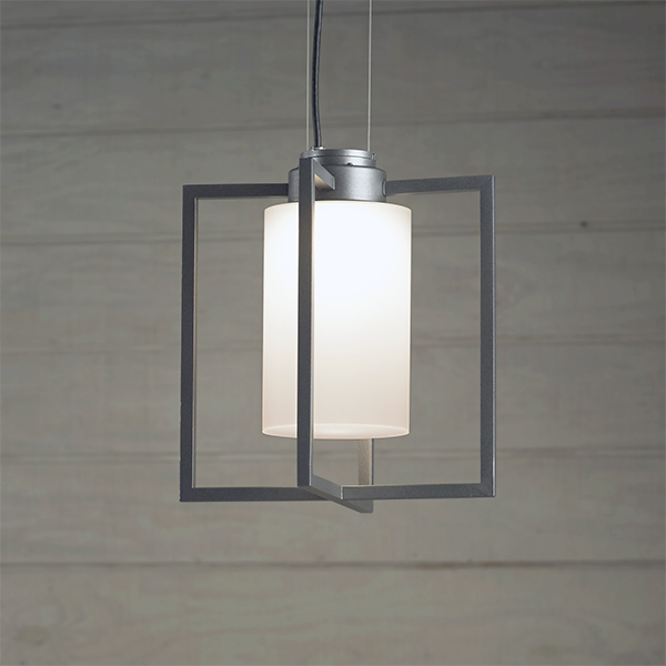 Laterna outdoor light fixture mounted on catenary cable from a brick wall. 