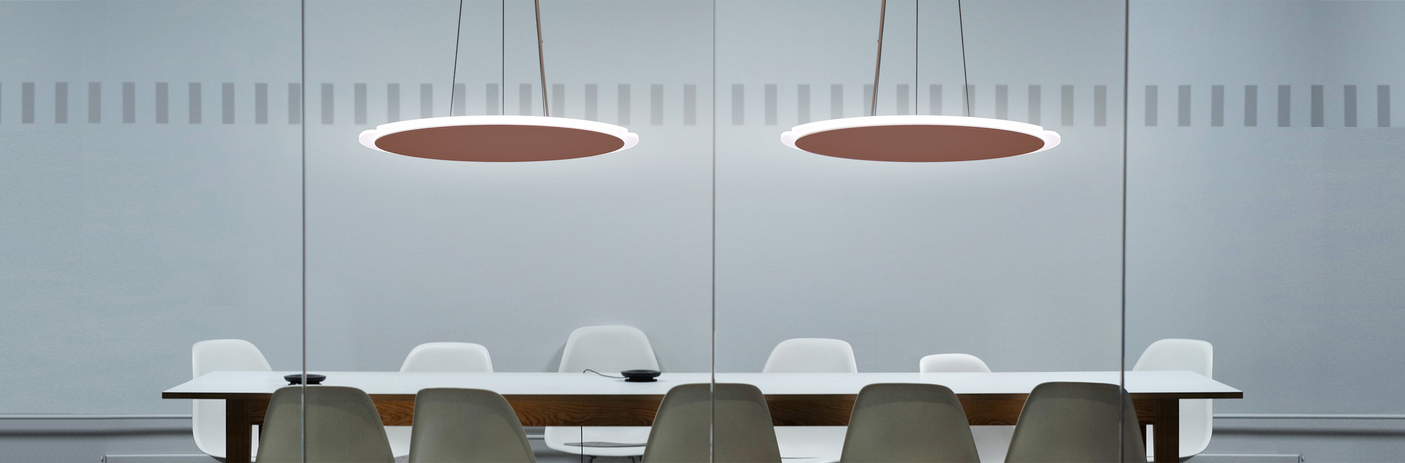 Chandelier of disk pendant lights hang in conference room over modern table and chairs. . 