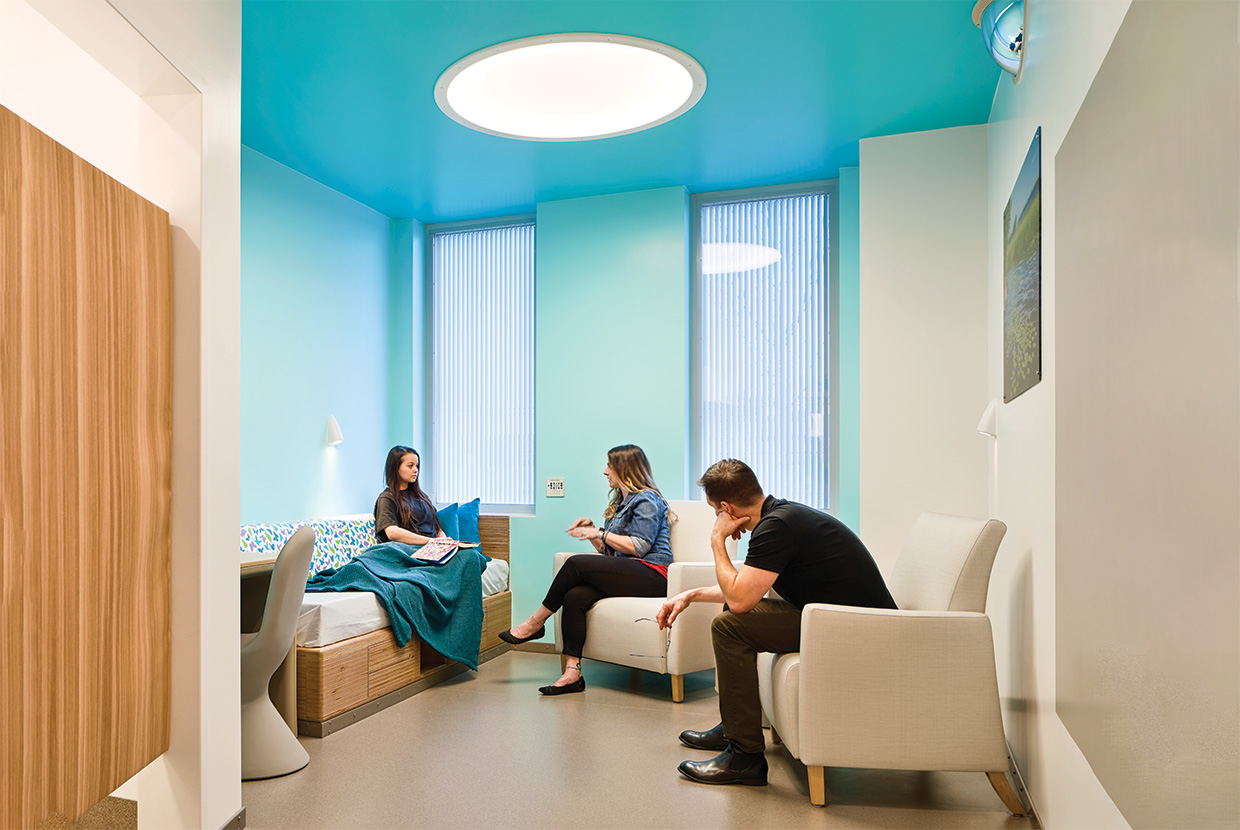 Behavioral Health room with family and blue calming walls and high abuse light fixtures