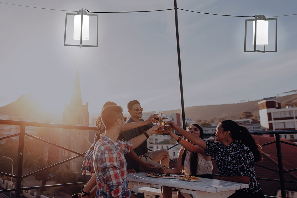 A group of lighting designers celebrates under the ambiance of outdoor pendant lanterns.