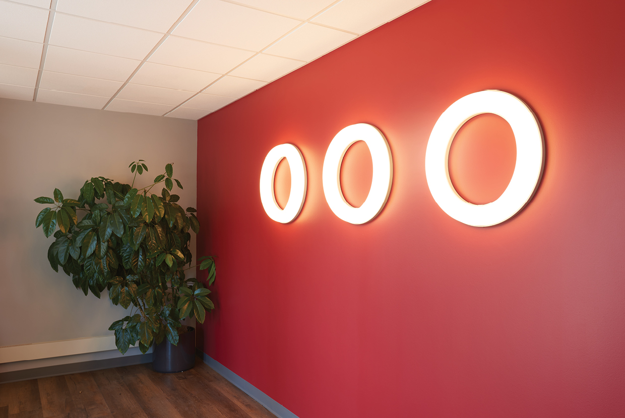 Meridian ring sconce lights on red lobby entrance wall. 