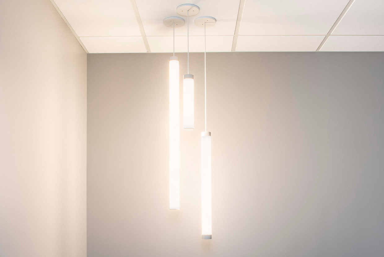 Group of three cylinder pendant lights clustered into corner of office