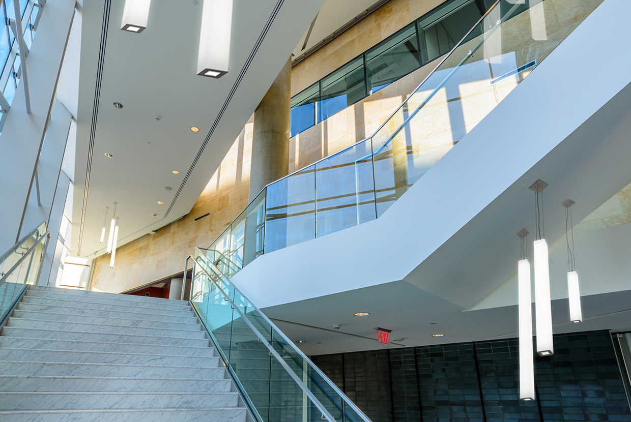 Modern glass stairwell with luminous rectilinear pendants