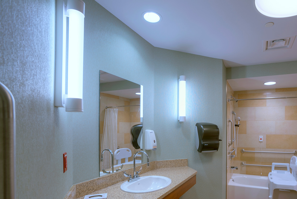 Asta modern vanity light fixtures provide accurate, stylish light for a nursing center bathroom.