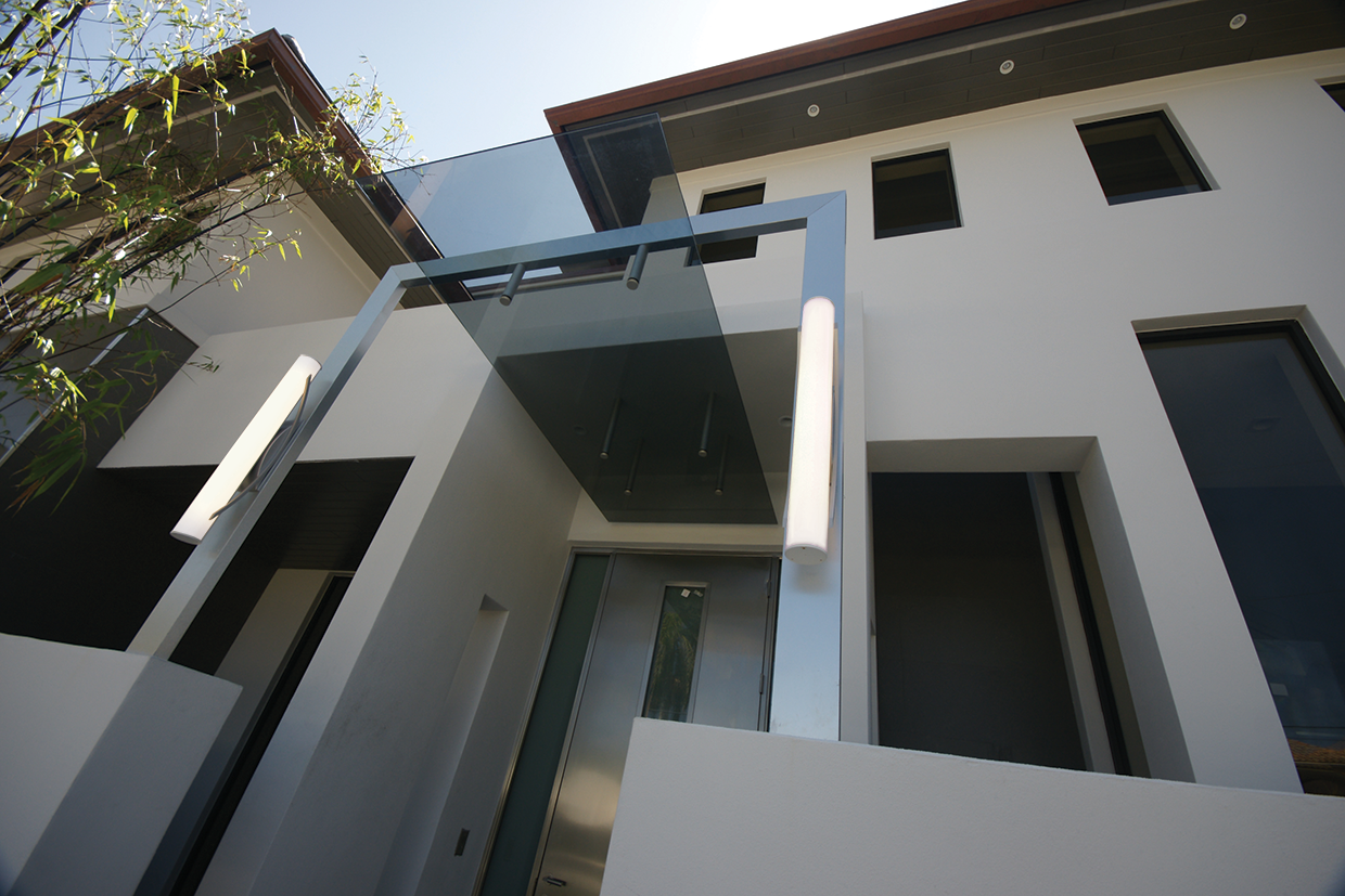 Architect's home exterior entryway with large outdoor sconce lighting around front door. 