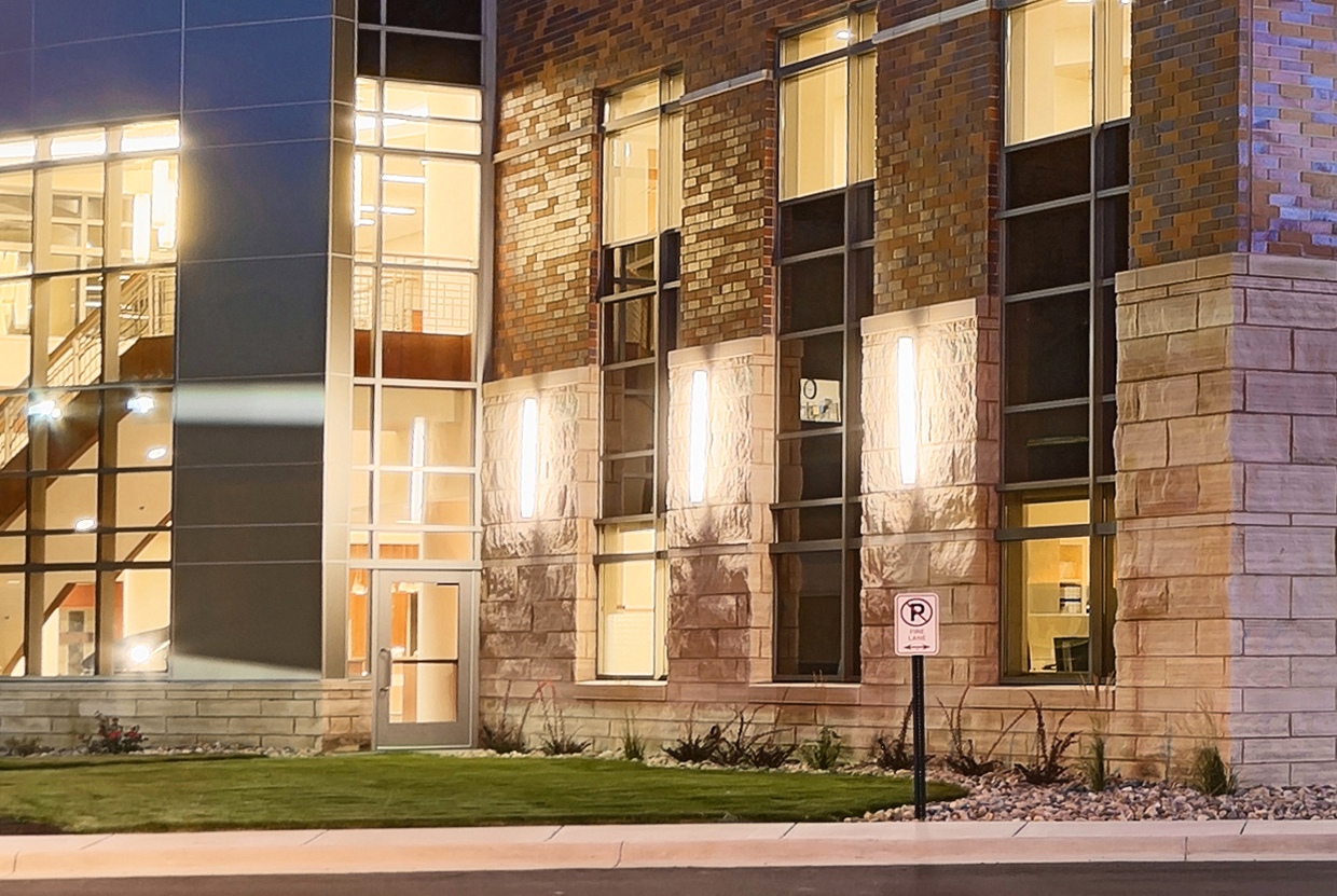 Brick columns on front of hospital with large outdoor sconces. 