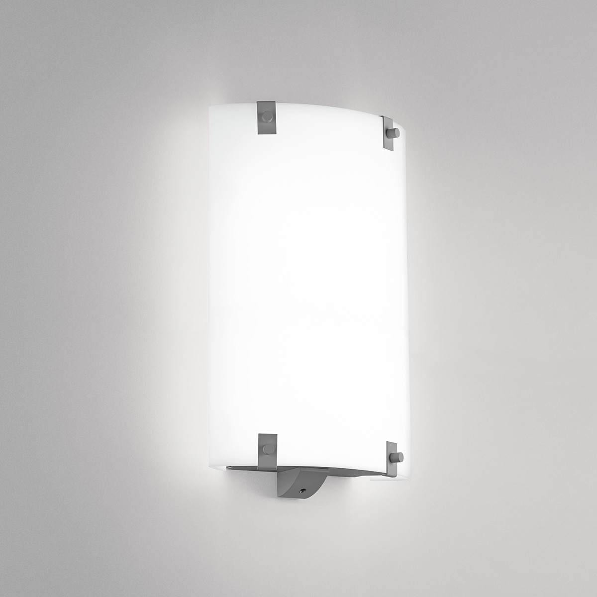 A small, rectangular wall sconce with button accents