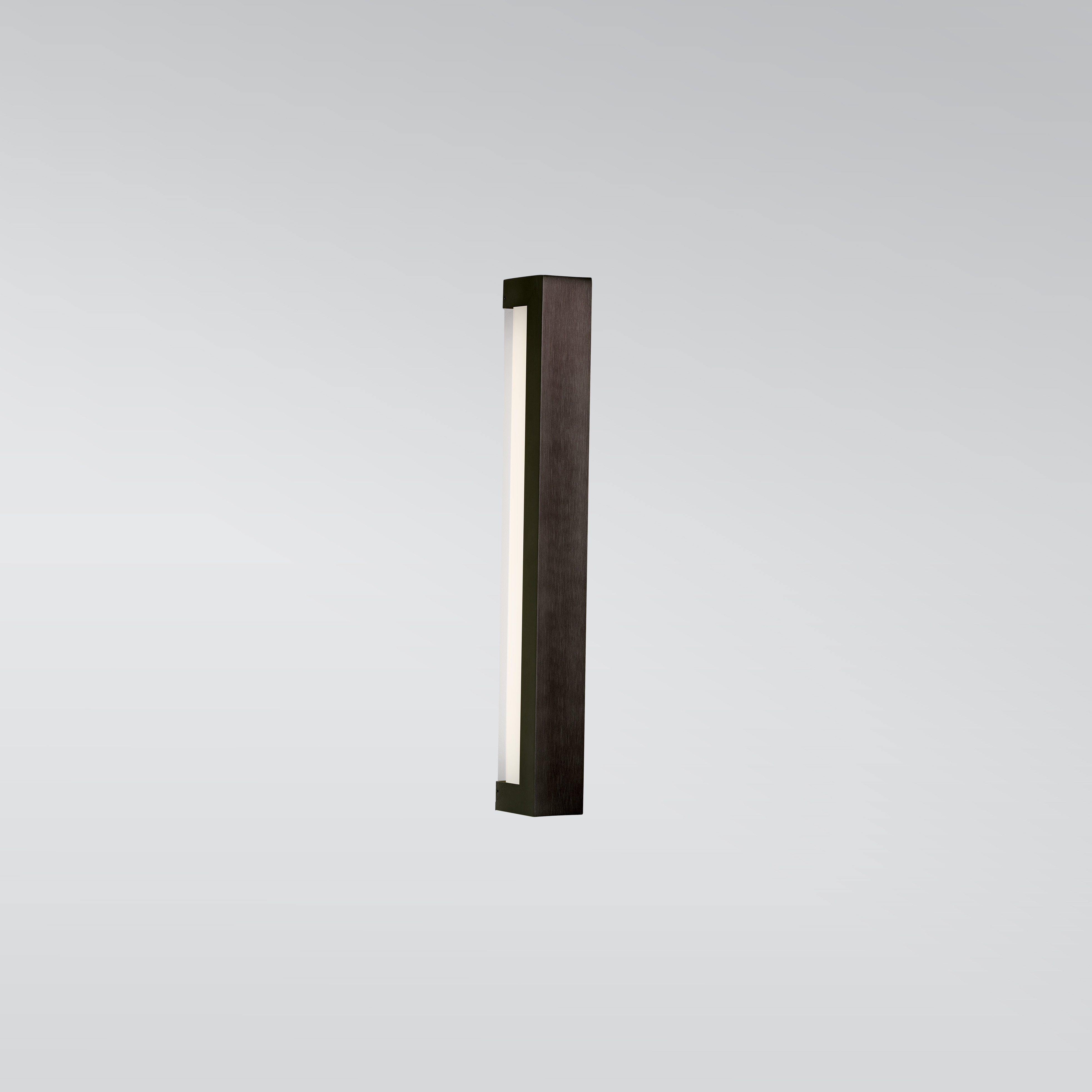 A linear wall sconce with a solid outer body and a luminous diffuser underneath