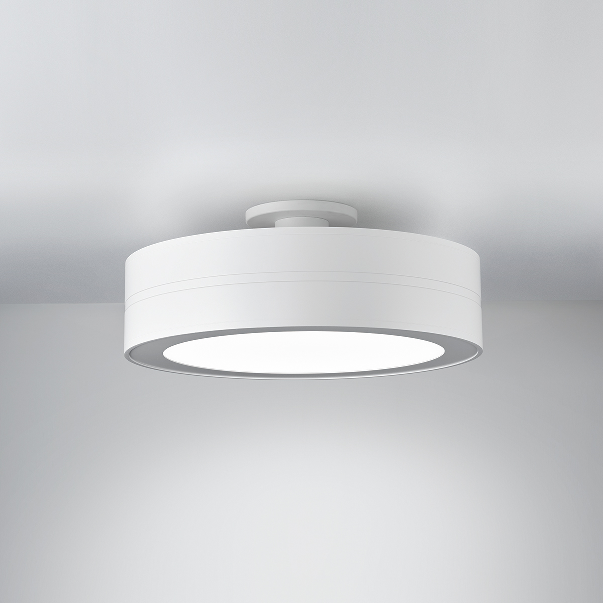 A ceiling-mounted drum luminaire with a light finish