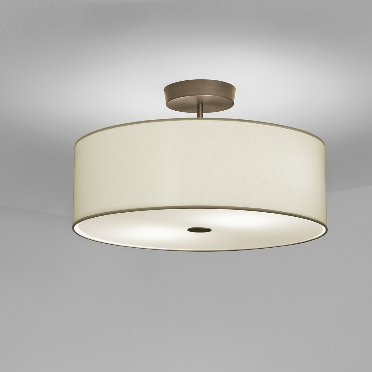 A ceiling mounted drum fixture with a fabric-looking shade