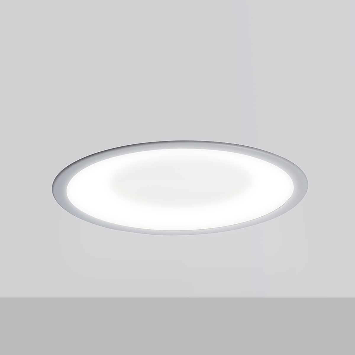 A round, recessed ceiling luminaire with a concave dome lens 