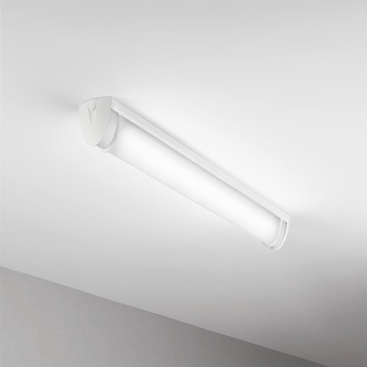 A luminous surface-mounted luminaire with a curved linear diffuser body and trim accents