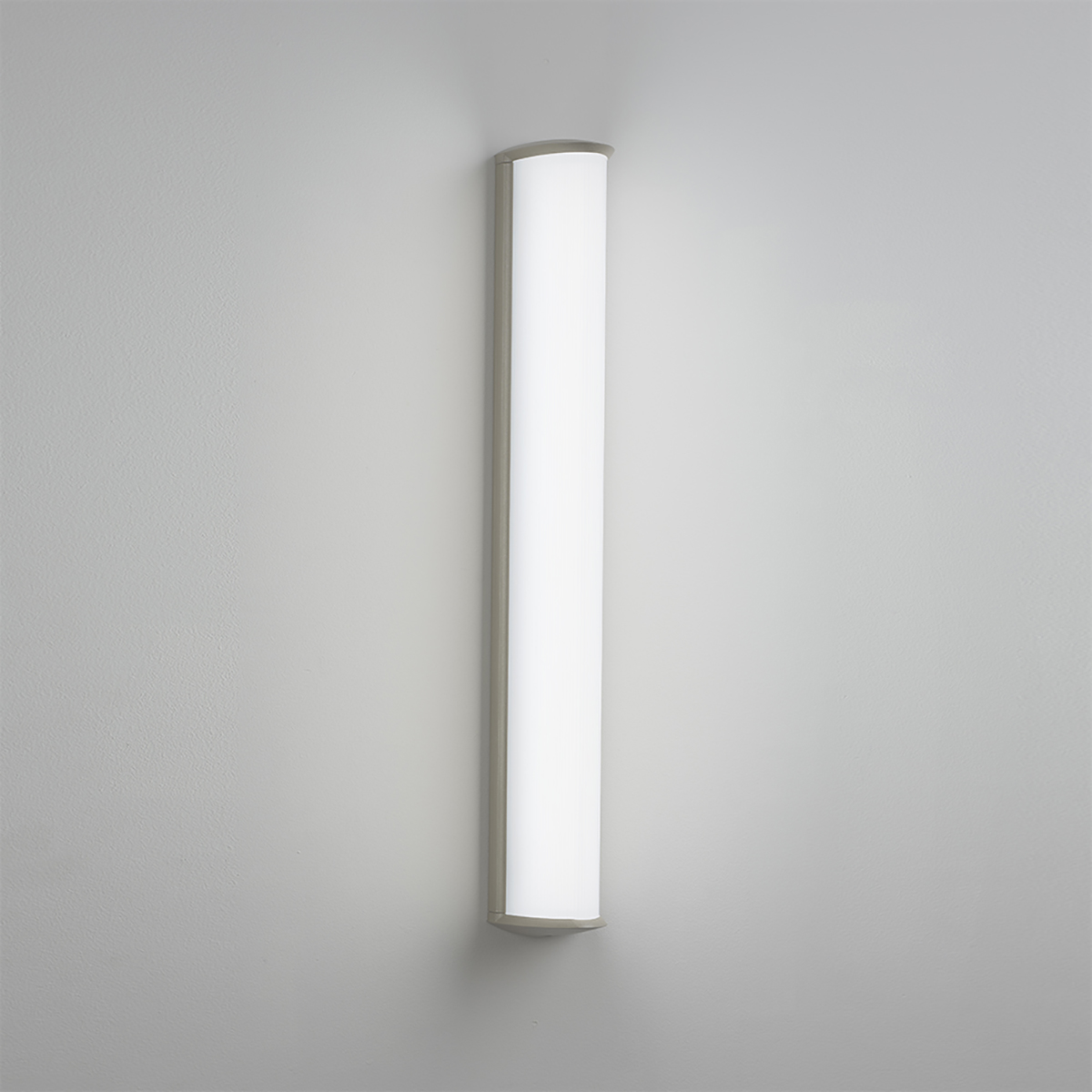 A luminous surface-mounted luminaire with a curved linear diffuser body