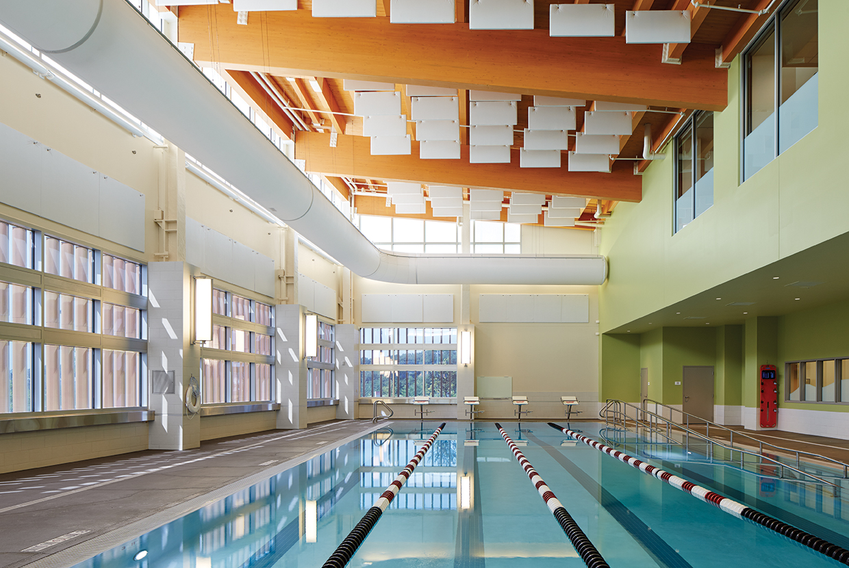 Air Foil sconces showing off modern lighting design along a well-lit indoor pool. 