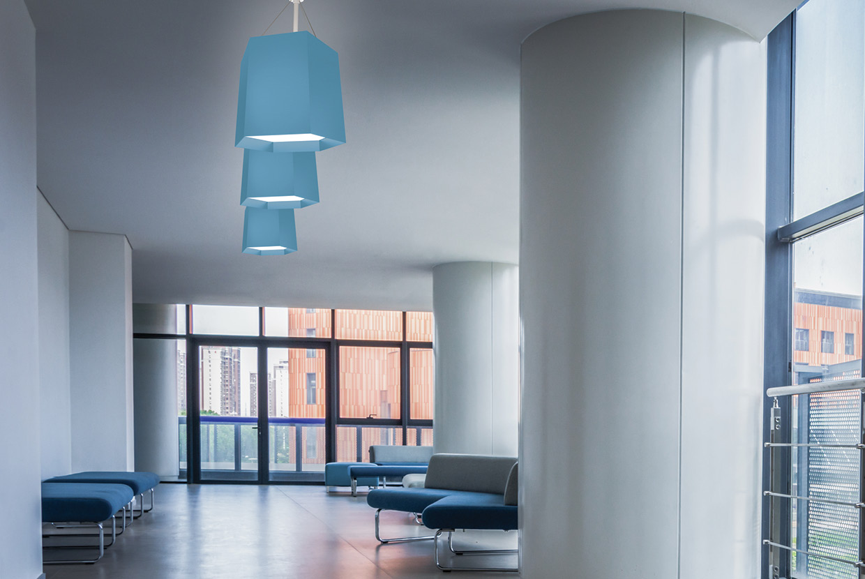 Three modern geometric hexagon pendant lights hung in healthcare lobby. 