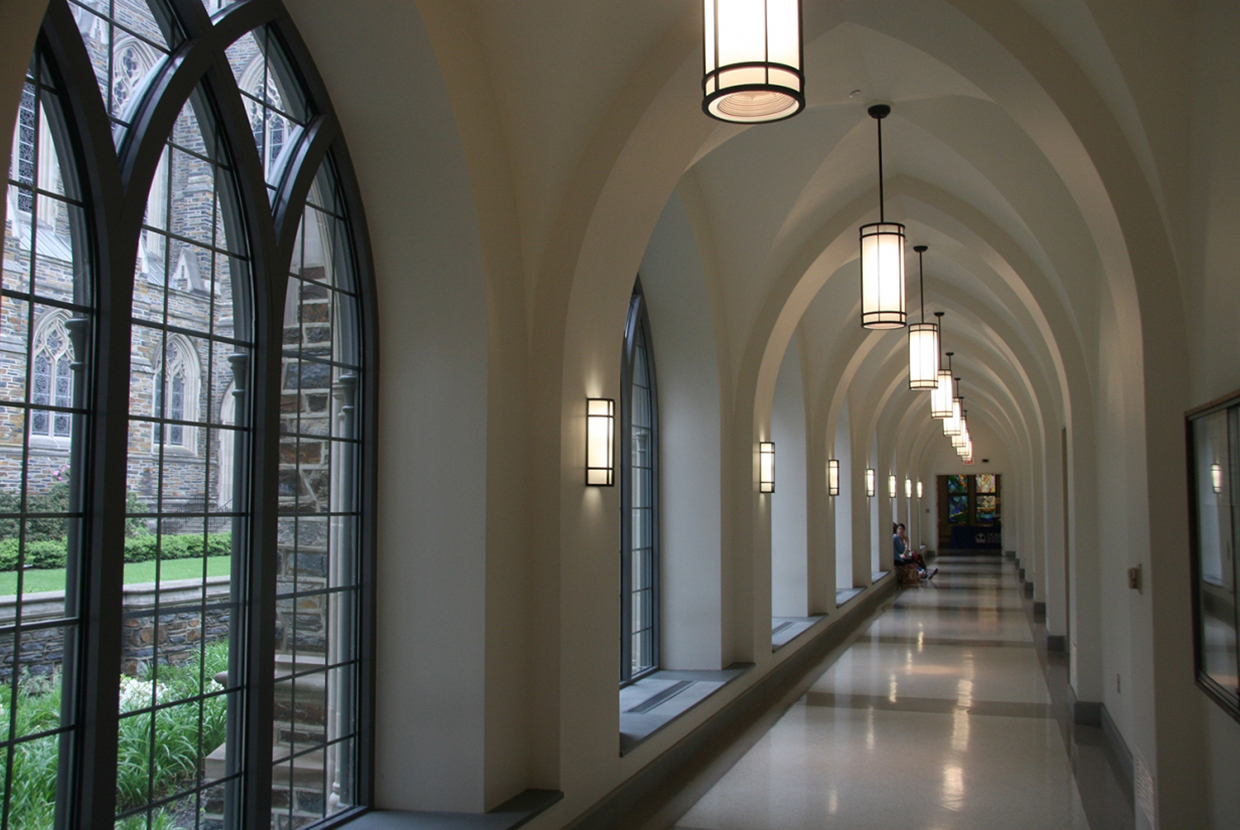 Colonnade wall sconces in an education lighting application alongside campus hallway artwork. 