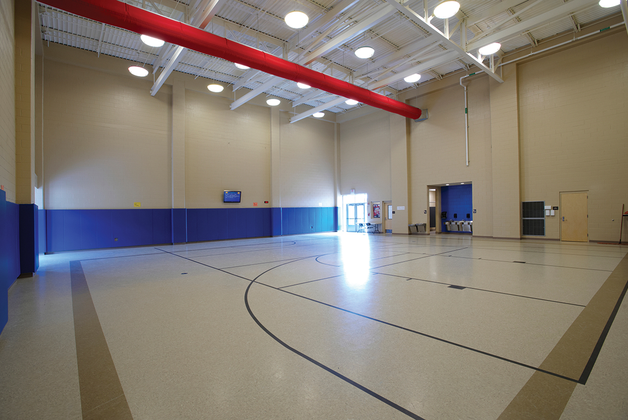 Midbay, a large light fixture for industrial and large venue applications, works well for this school gymnasium. 
