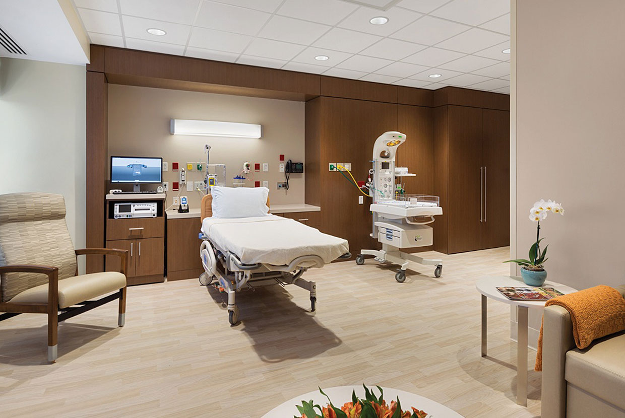 Unity headwall luminaire provides beautiful illumination for a large patient room lighting design with a seating area. 