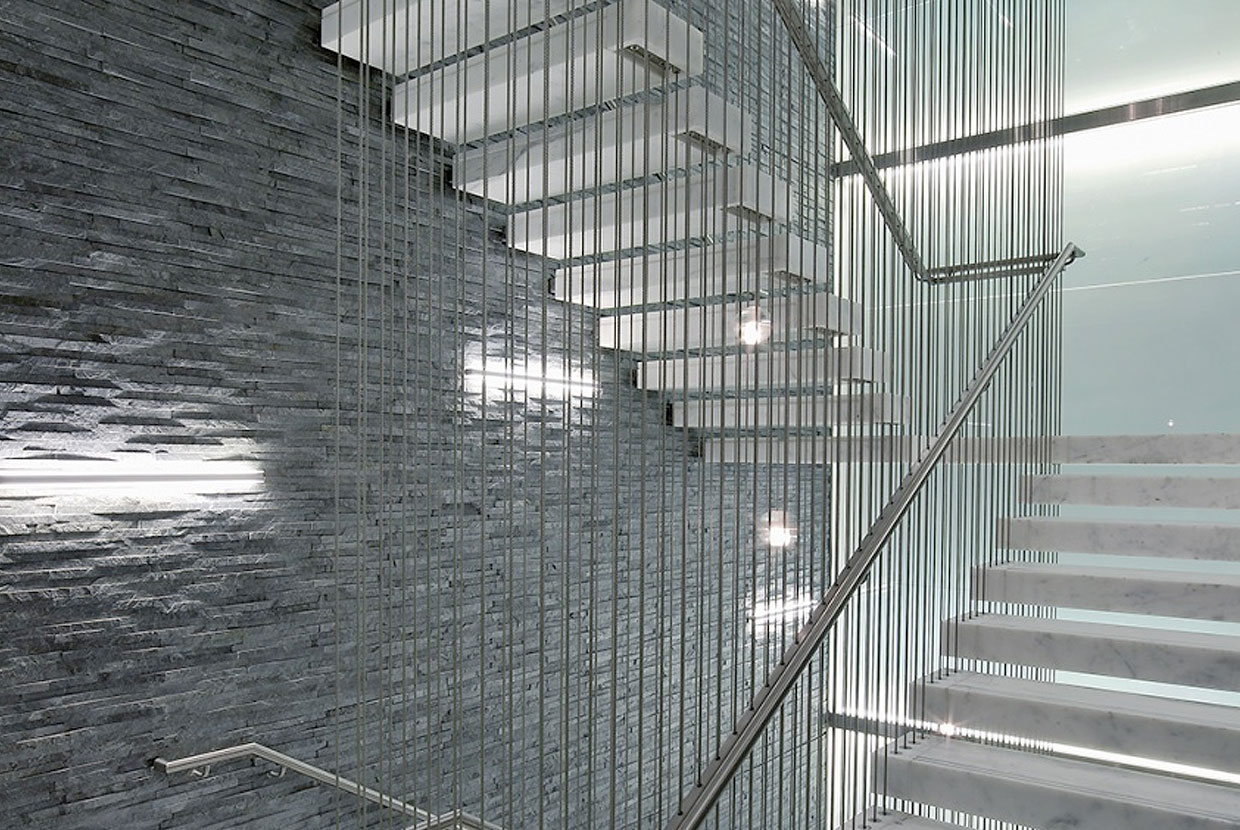 Sleight office lighting illuminating an ultra-modern textured stairwell wall. 
