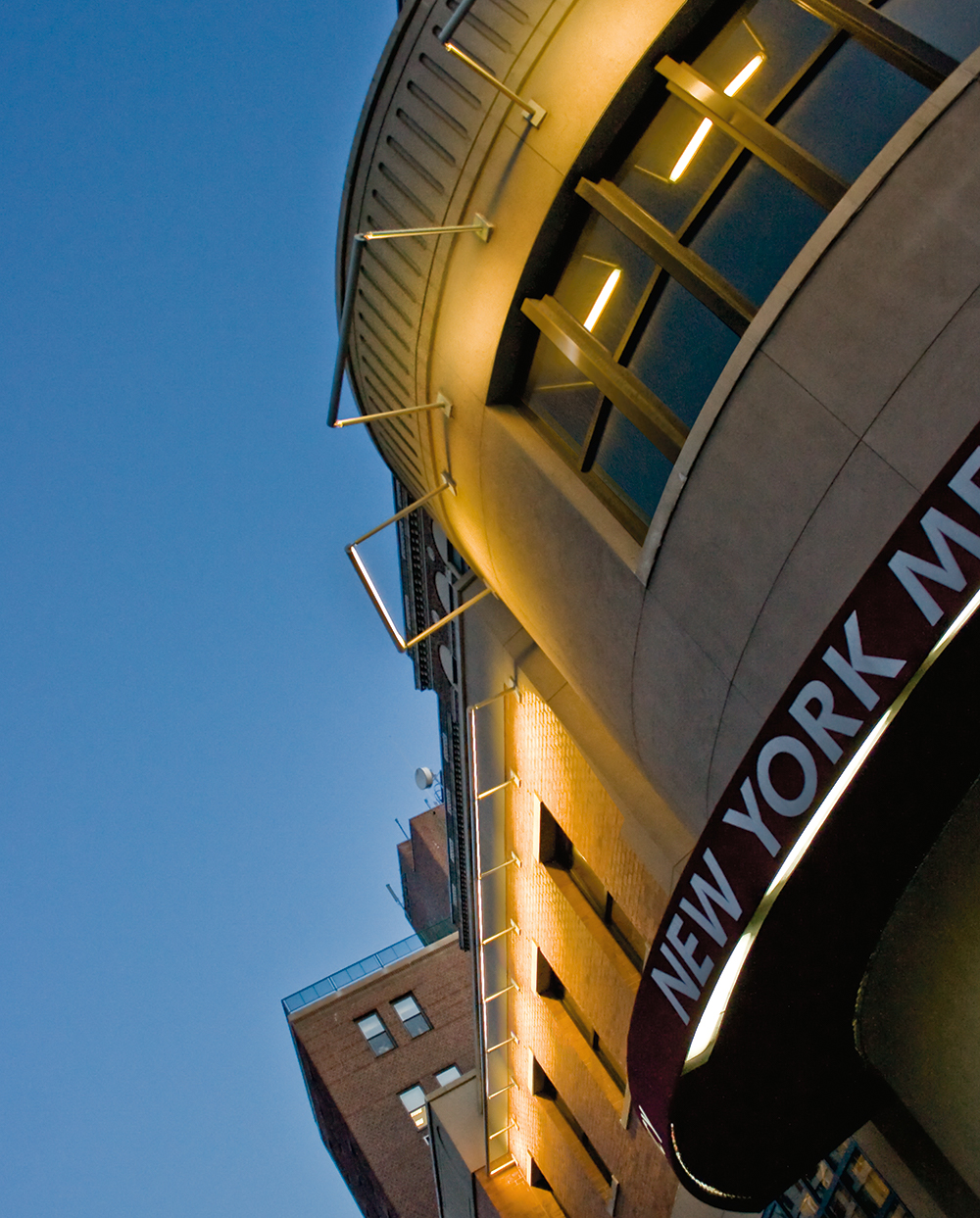 Advantus exterior lighting fixtures project light from a linear body onto hospital façade, without revealing the light source.