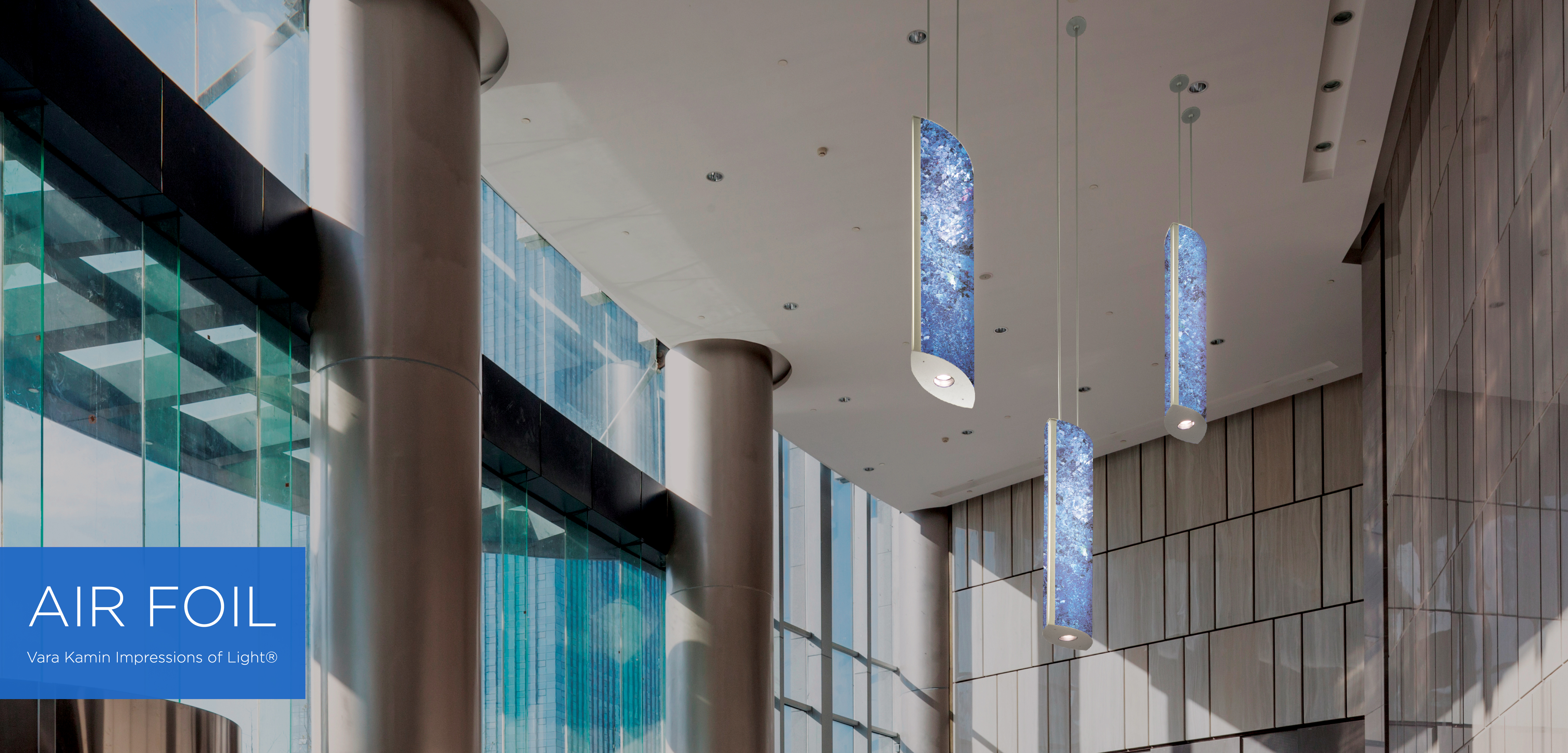 A luminous rectangular pendant supported by two aircraft cables 