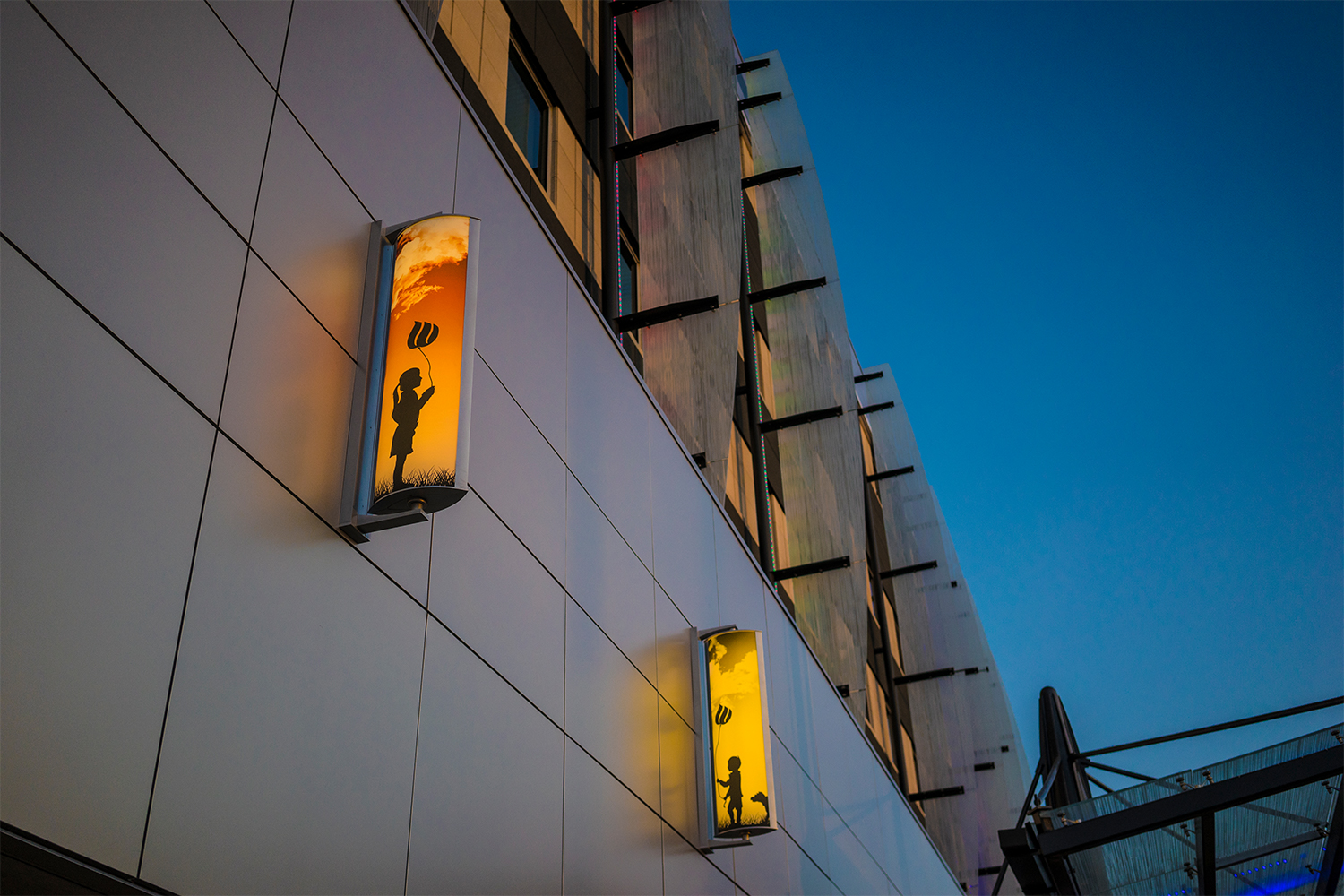 Air Foil custom light fixtures depict artistic silhouette's and deep sunsets as they light a children's hospital façade.