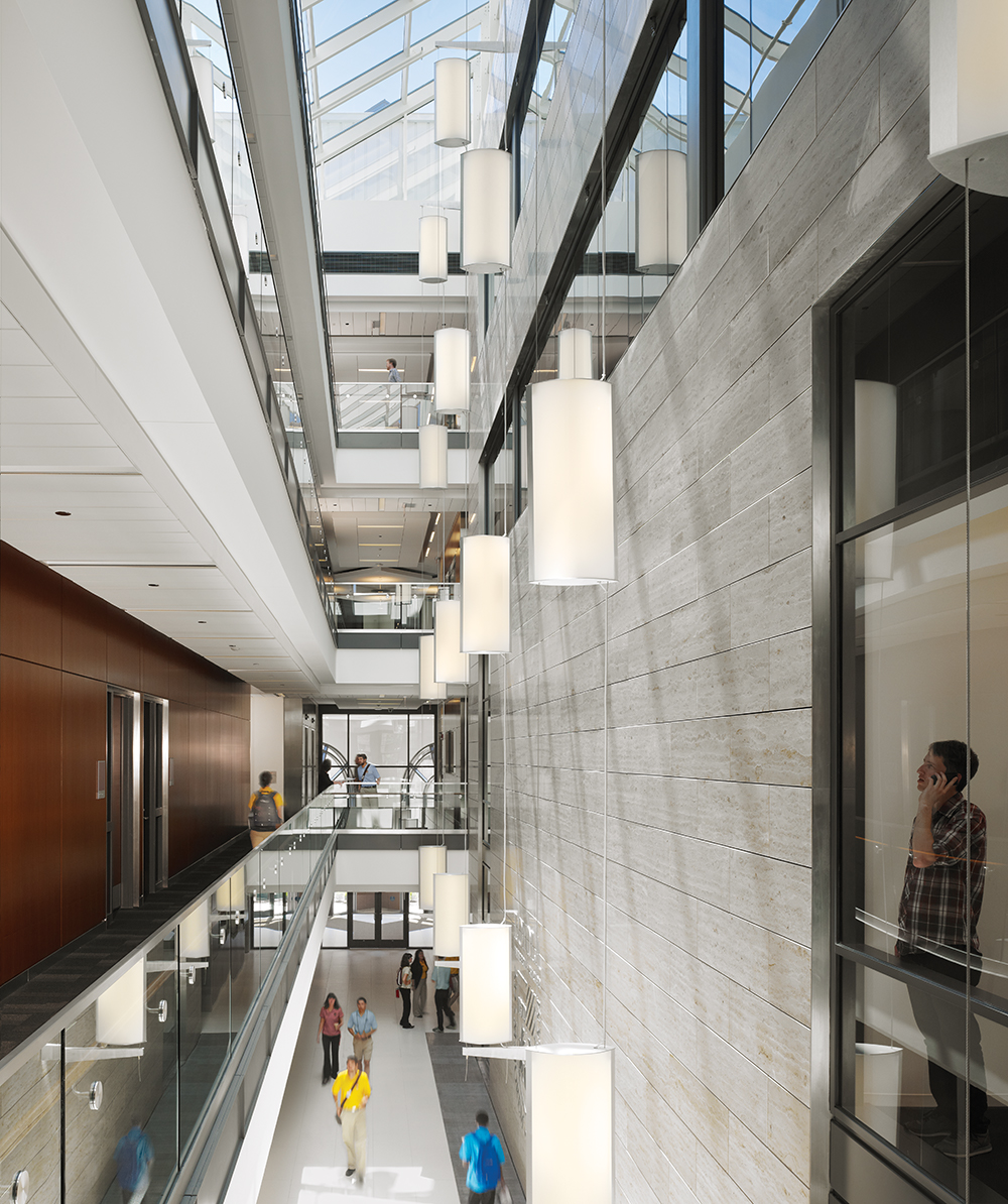 Custom light fixtures designed with Air Foil luminaires hung in tandem along a multi-floor atrium.