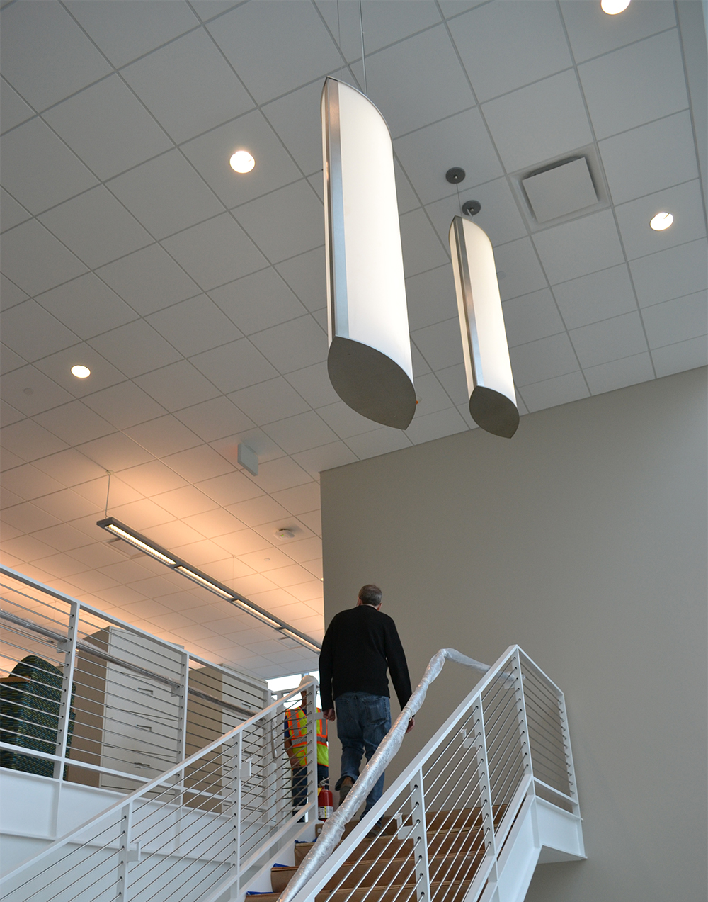 Air Foil pendants mounted above a stylish healthcare design. These two large fixtures illuminate a stairwell.