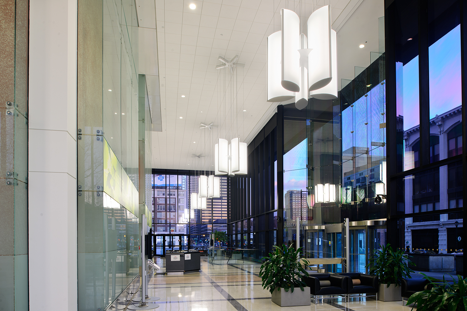 Air Foil pendants configured in multiple star-shaped clusters for stylish lobby lighting that reflects in the glass windows.