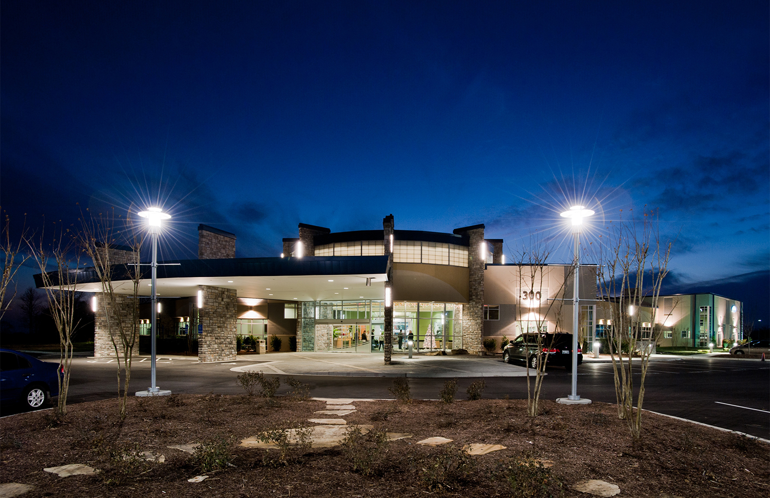 Avatar exterior lighting fixtures on a healthcare building illuminate support columns with clean, even light.