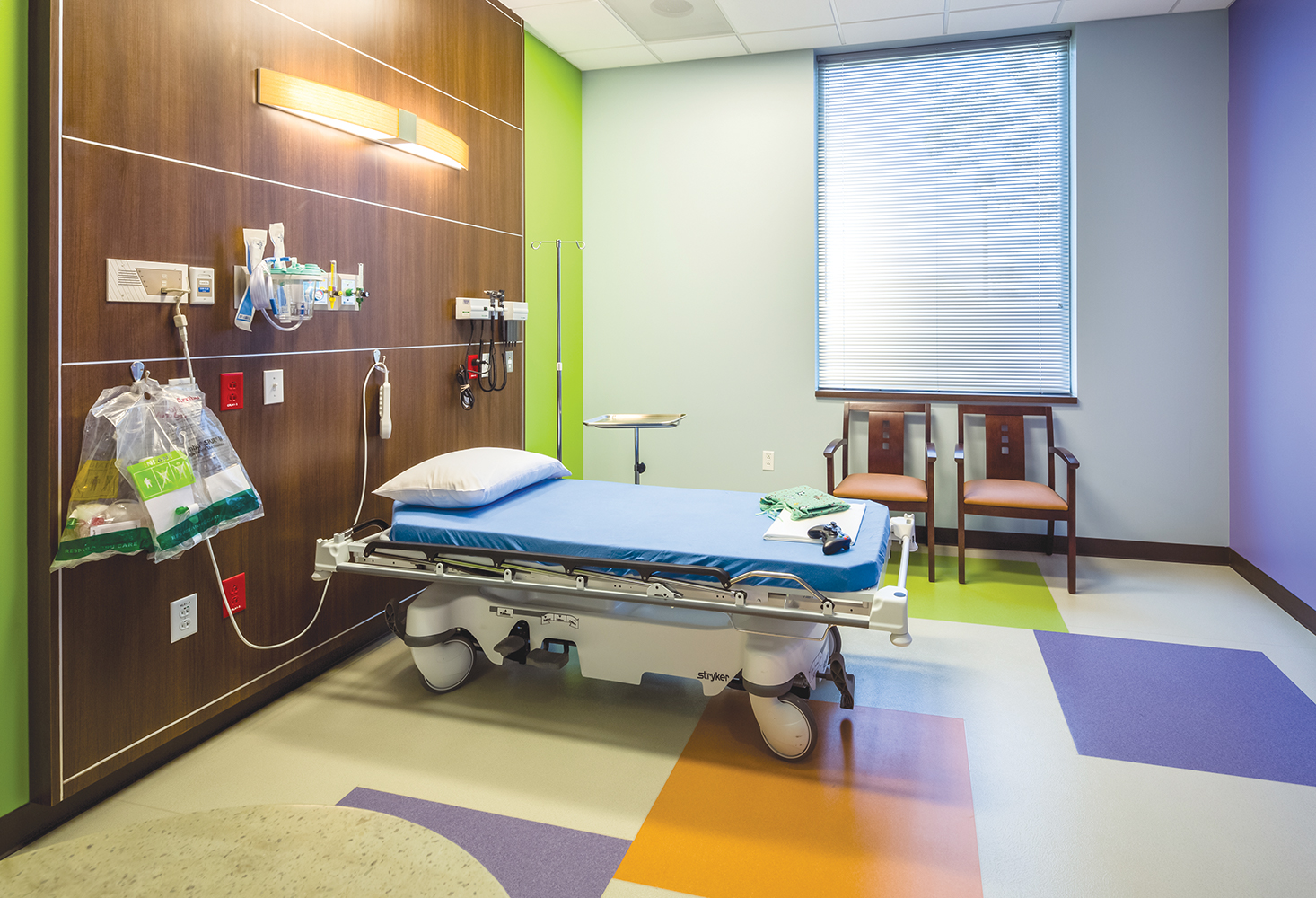 Bowe patient room lighting fixture mounted horizontally over a hospital bed.