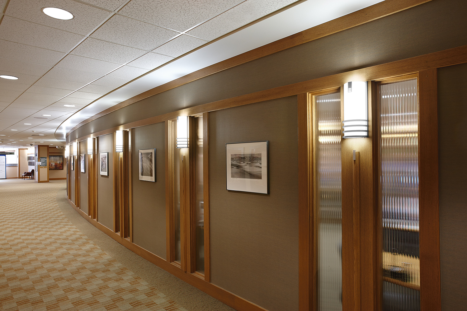 Colonnade wall sconces are classic office lighting fixtures, seen here along an interior hallway.