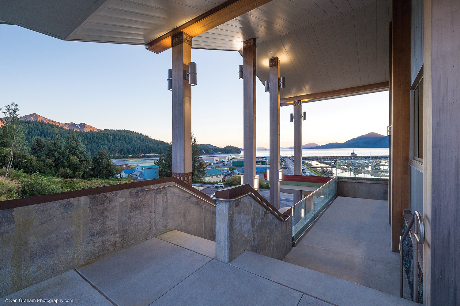 Colonnade and Scope outdoor lighting fixtures illuminate the support columns of a beautiful waterfront building.