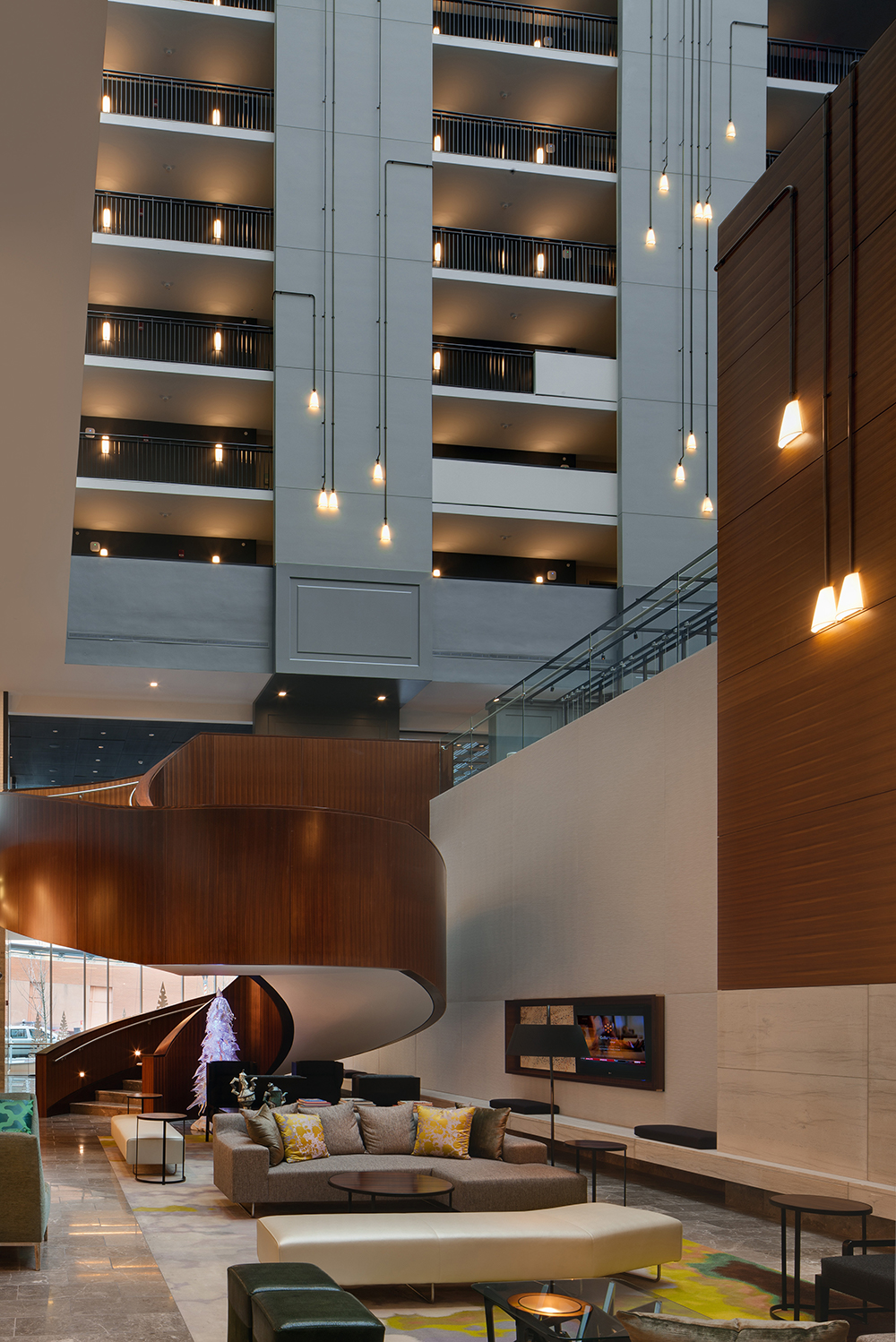 Unique, A-shaped custom light fixtures with square-angled black connecting pipes in a hotel lobby.