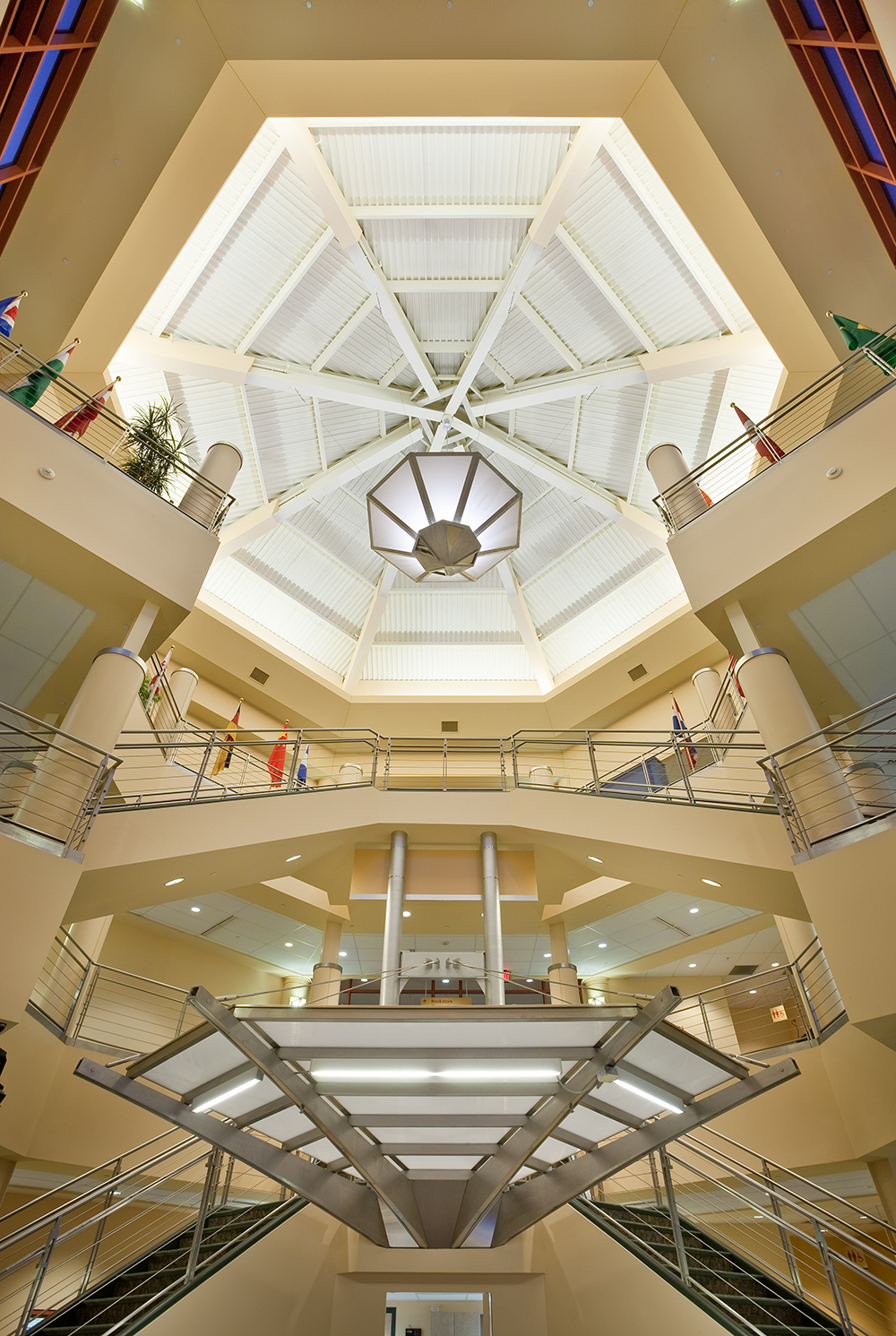 Large, geometric custom light fixtures hang from an open multi-level atrium.