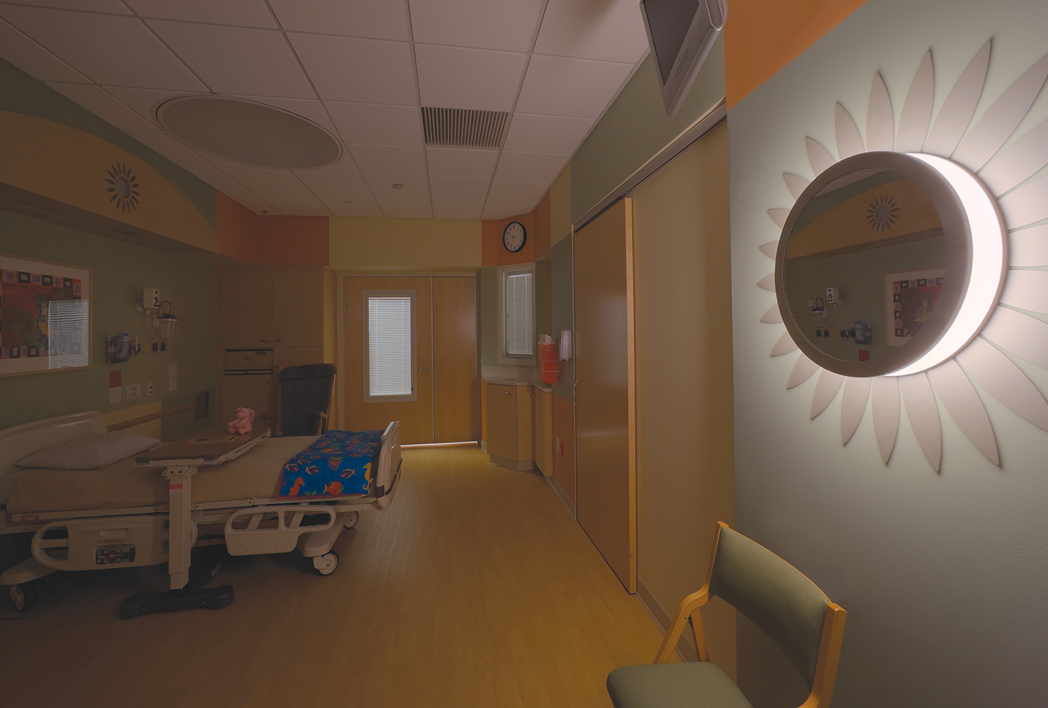 These custom light fixtures were tailored in a sunflower shape and center mirror to light up this children's hospital patient room.