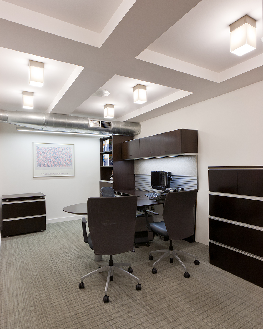 These custom light fixtures are clean, rectangular downlights for a sophisticated white and brown themed office.