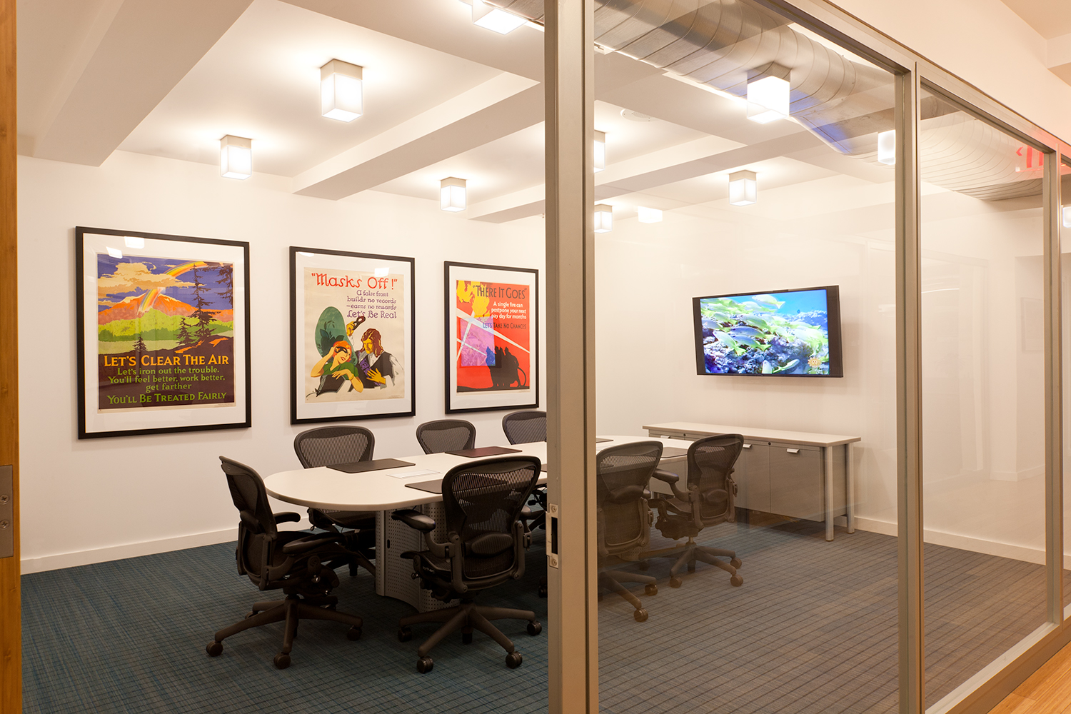 These custom light fixtures are clean, rectangular downlights for a sophisticated office conference room.