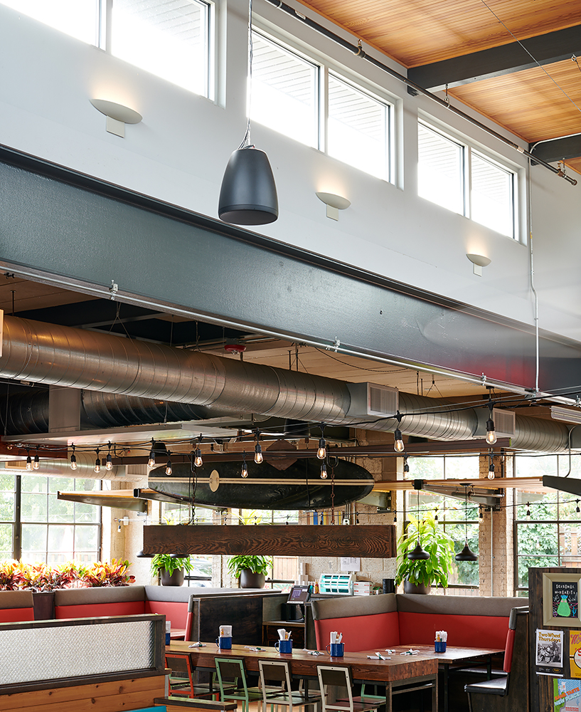 Escape wall sconces are perfect for modern commercial lighting, seen here above a restaurant dining area