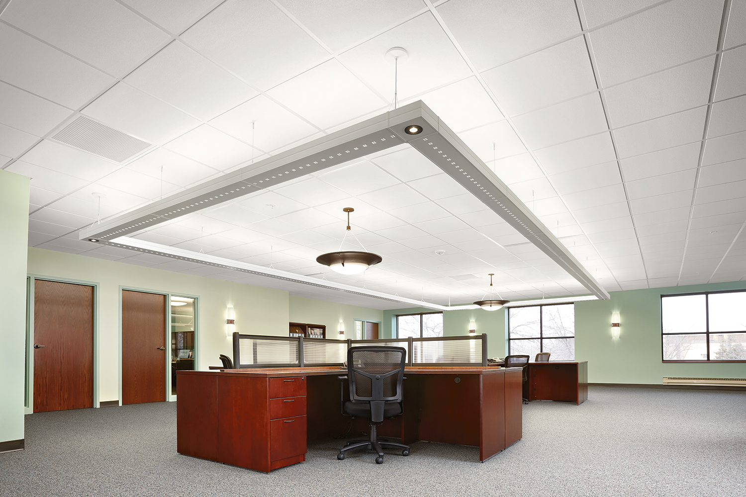 Infinity Performance large linear suspended luminaires in a rectangular configuration above an open office with Pila sconces.